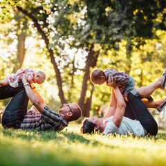 Parents playing with their young children in a park